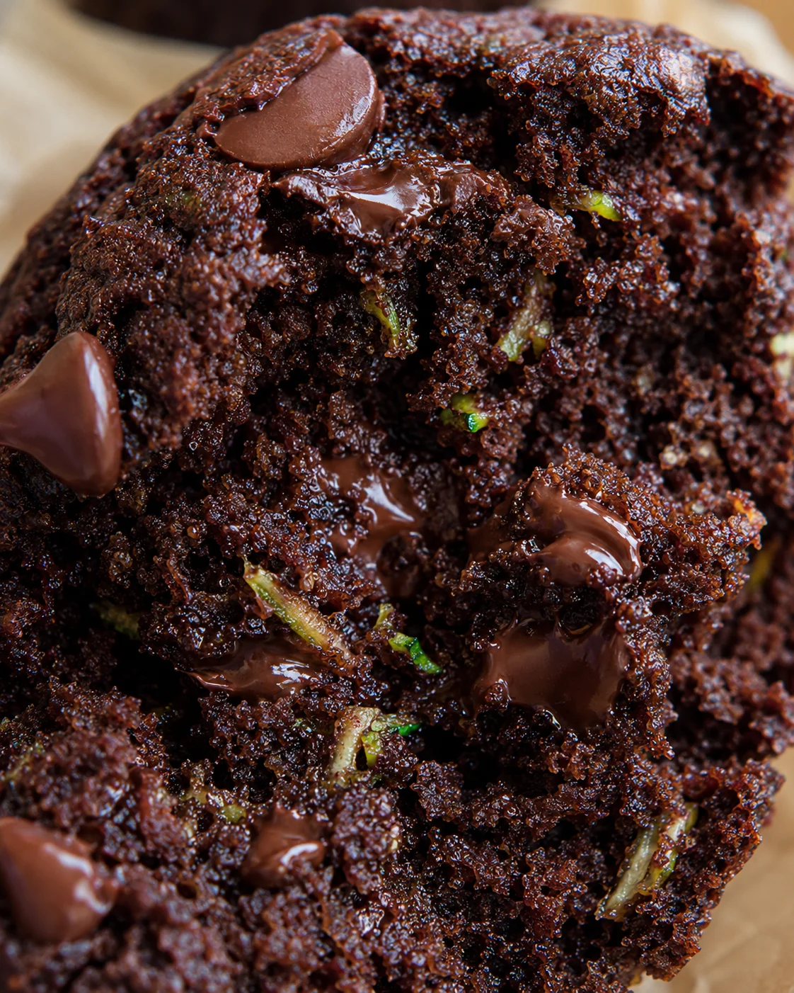 Close-up of moist chocolate zucchini muffins with chocolate chips and grated zucchini