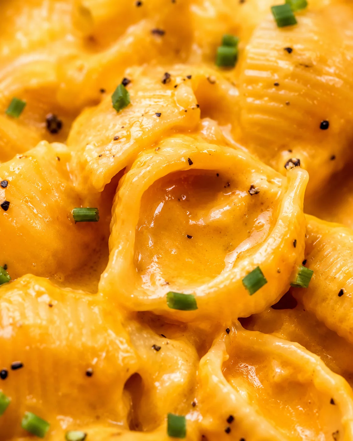 Close-up of creamy pumpkin mac and cheese with cheese sauce and chives