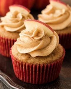 Close-up of moist apple cider cupcakes with spiced buttercream frosting and apple slices