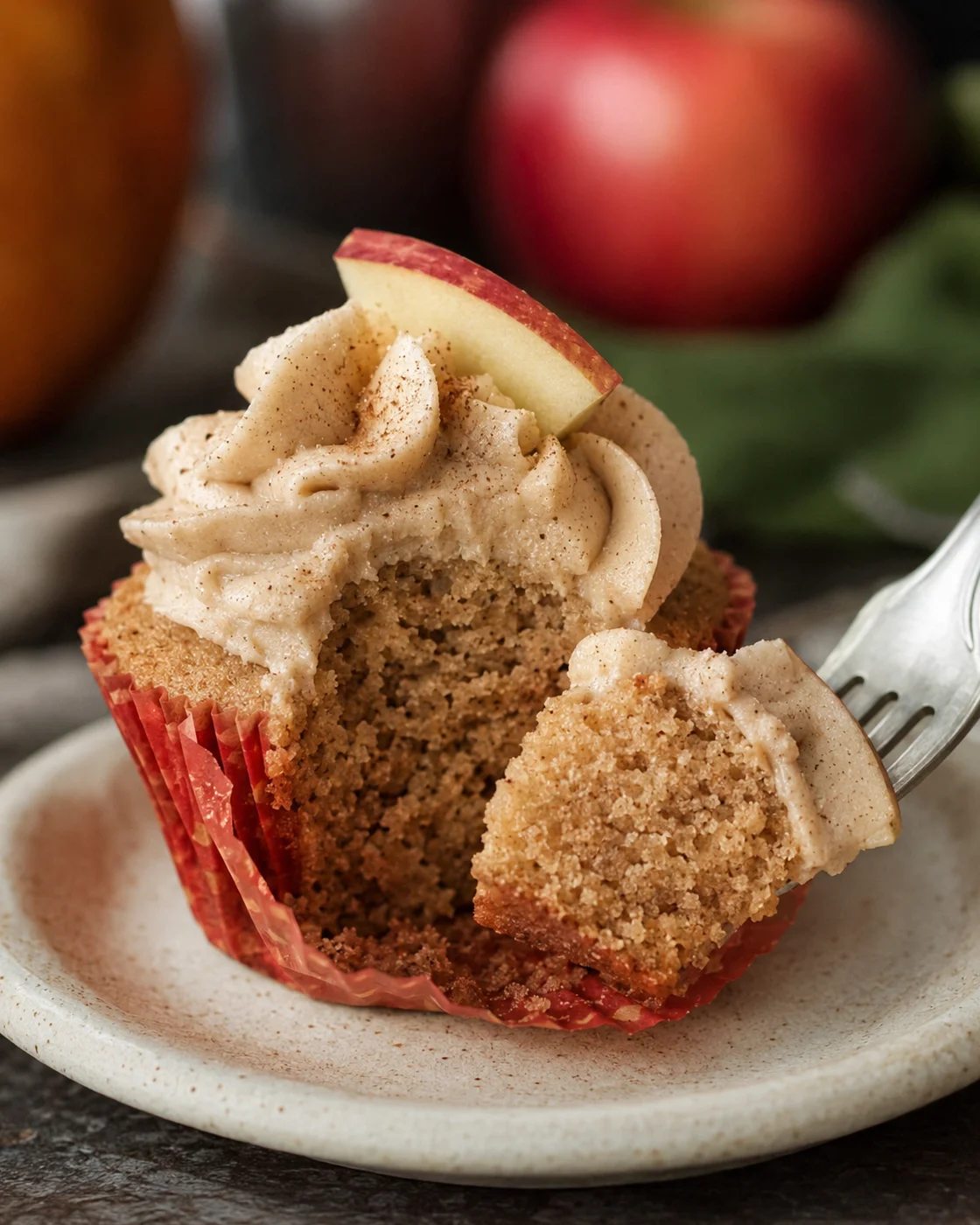 Close-up of moist apple cider cupcake topped with spiced buttercream frosting.