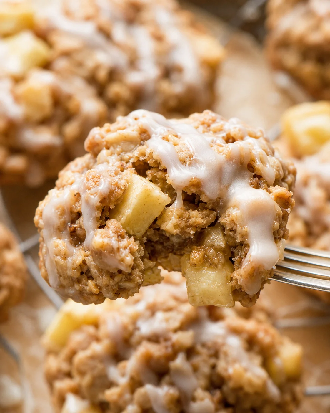 Close-up of a soft apple cinnamon cookie with maple glaze drizzle